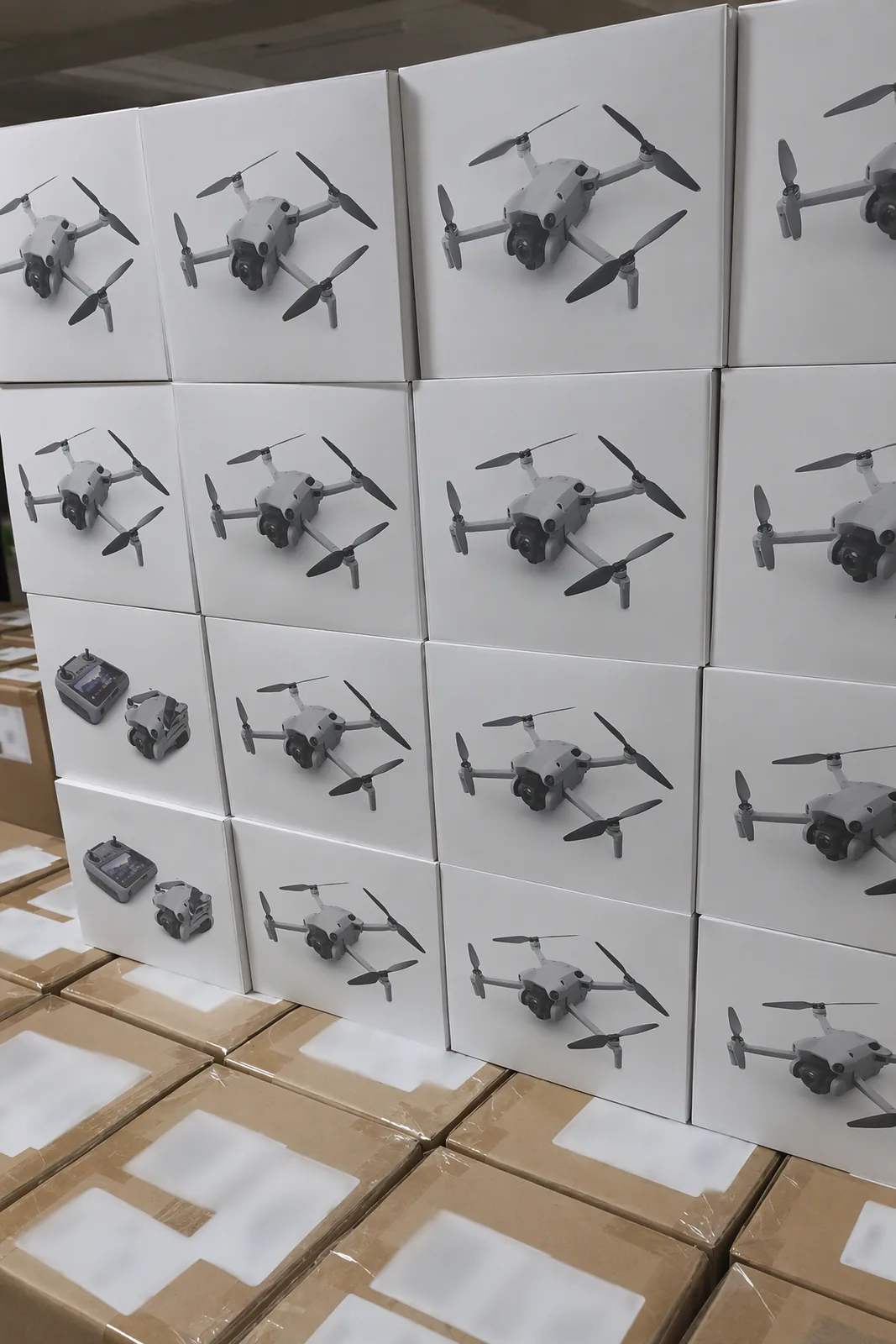 Boxed DJI Mini drones stacked on shipping cartons; the carton labels are blurred
