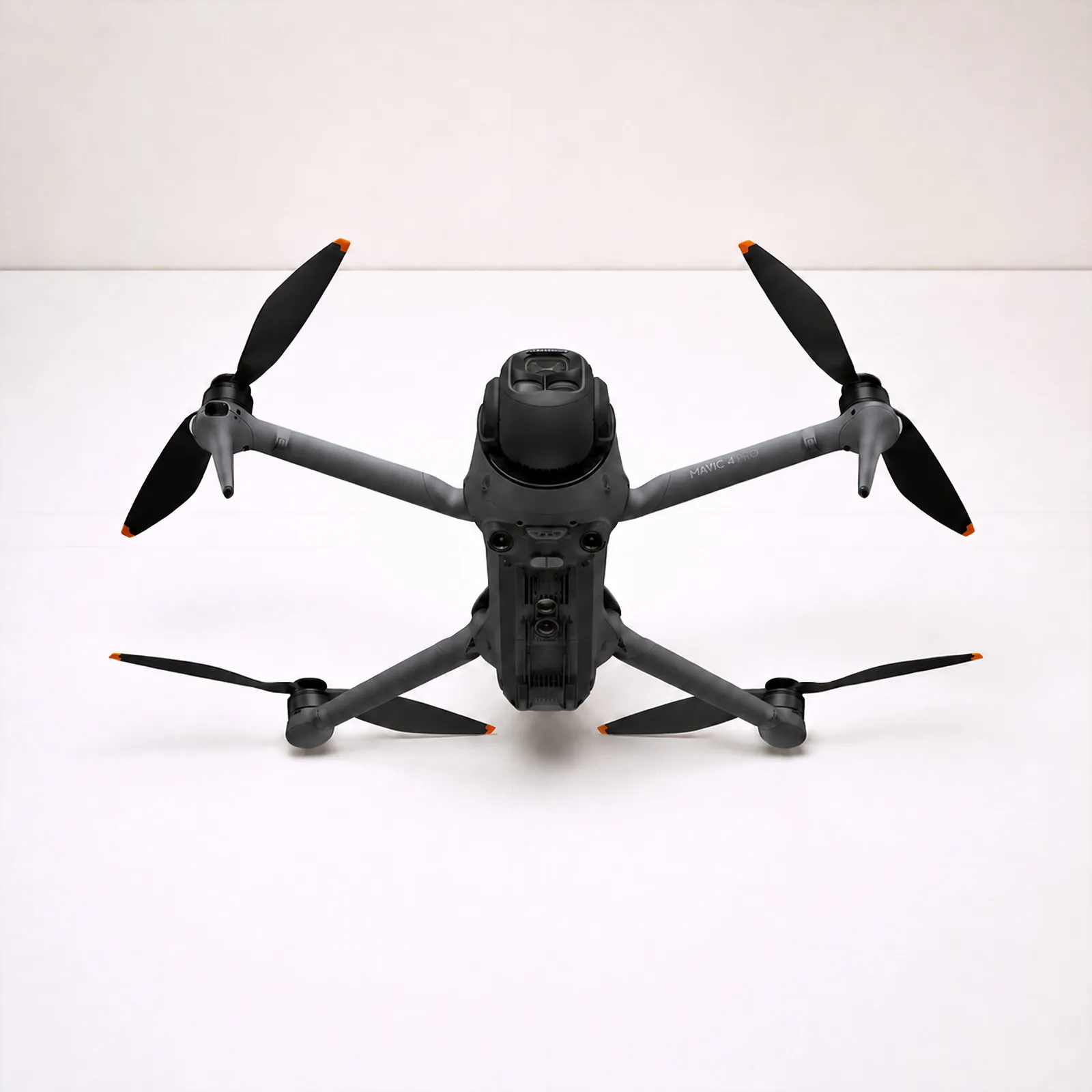 A used DJI Mavic 4 Pro, arms unfolded, photographed from the front on a white bench